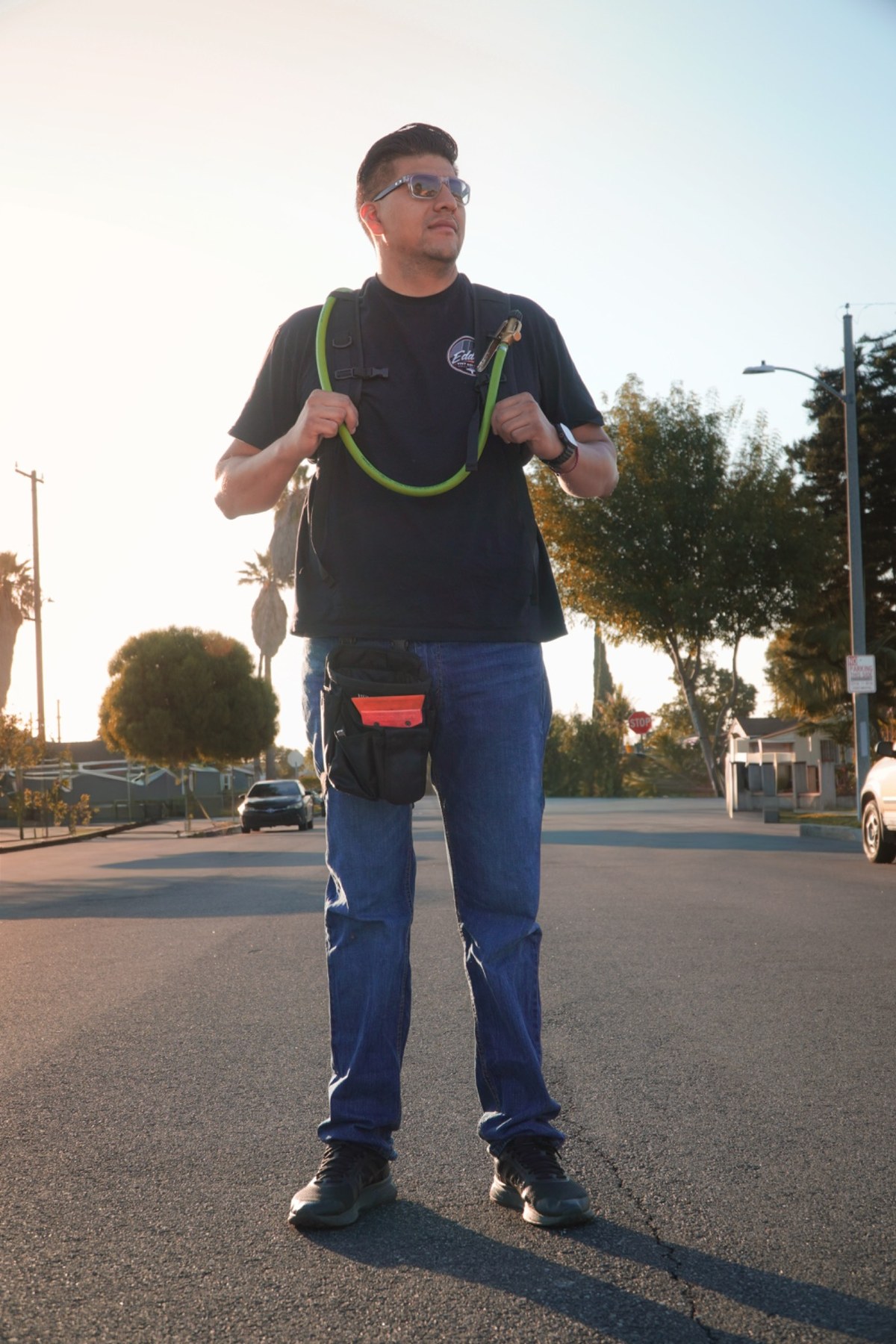 Eddie of Eddie's Tint Solutions in a branded shirt with his tool pouch and spray rig, ready for a mobile tint appointment