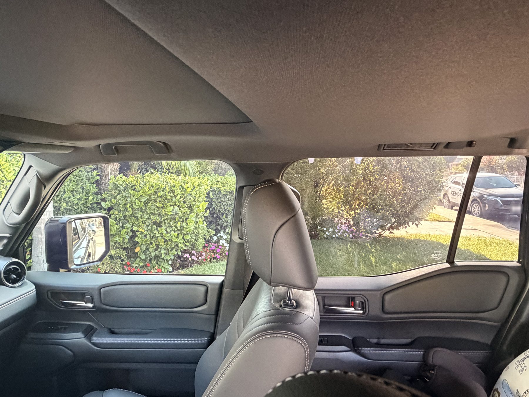 The same view from inside the SUV after tinting, the scene outside still clearly visible through the film but noticeably darker with the glare cut down