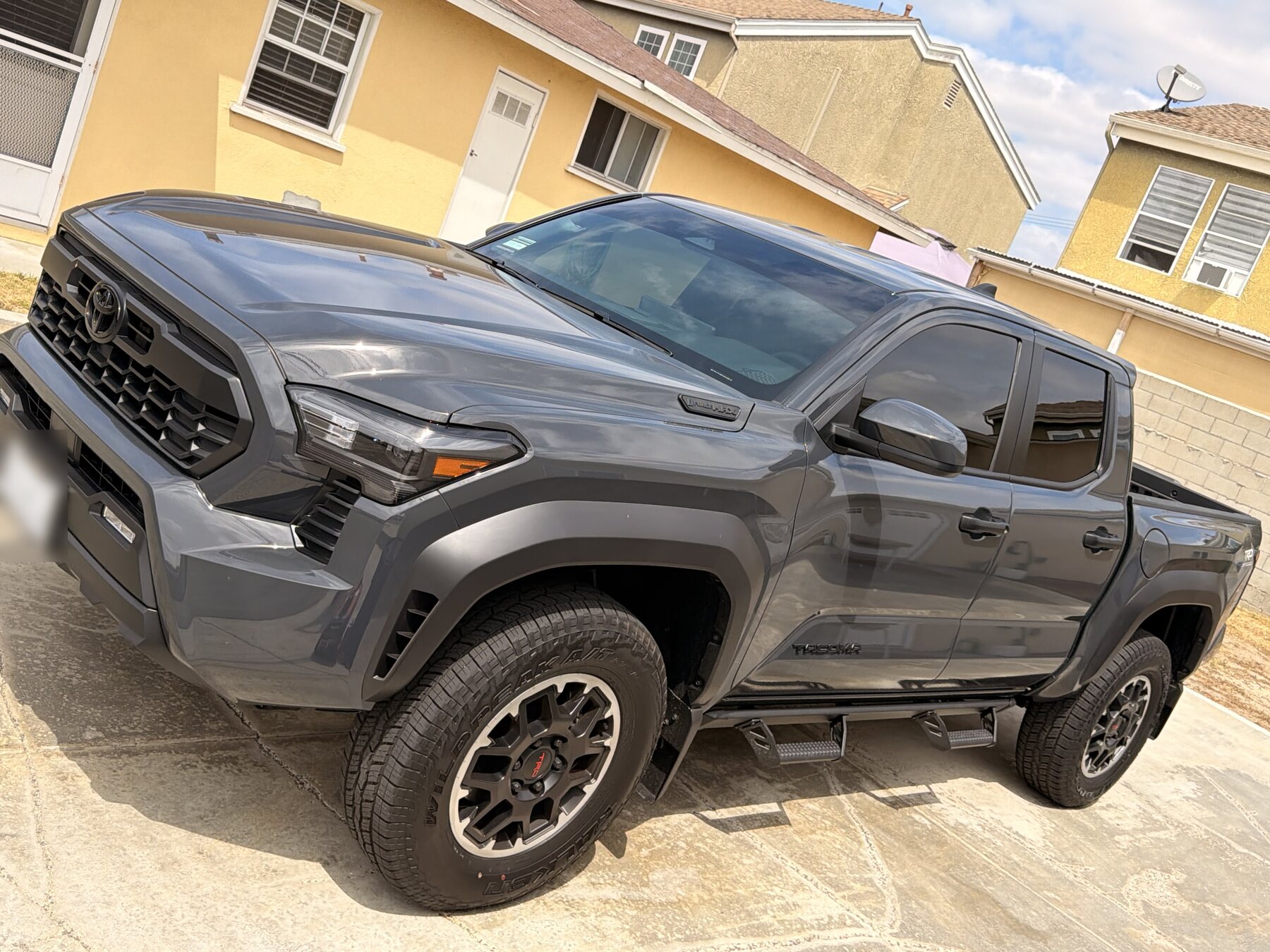 Gray Toyota Tacoma crew cab with freshly installed dark window tint